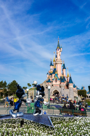 Marne-la-Vallee, France - March 10, 2017 : The Castle of Disneyland Paris, and in front of it, the statue of Mickey and Minnie, made for the 25th anniversary of the entertainment resort.のeditorial素材