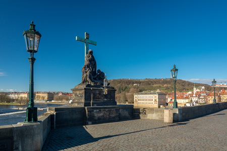 Prague, Czech Republic - April 5, 2018 : View of the Charles Bridge and an old statue by the river, with tourists visiting.のeditorial素材