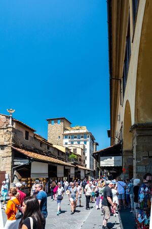 Florence, Italy - June 5, 2019 : The Ponte Vecchio (Old Bridge) is a medieval stone closed-spandrel segmental arch bridge over the Arno River, noted for having shops built along it. The present tenants are jewelers, art dealers and souvenir sellers.のeditorial素材