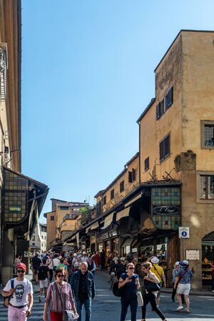 Florence, Italy - June 5, 2019 : The Ponte Vecchio (Old Bridge) is a medieval stone closed-spandrel segmental arch bridge over the Arno River, noted for having shops built along it. The present tenants are jewelers, art dealers and souvenir sellers.のeditorial素材