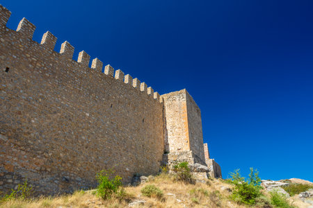 Detailed view of the crenellated medieval fortress wall rising against a deep blue sky in the historic town of Albarracin.の写真素材