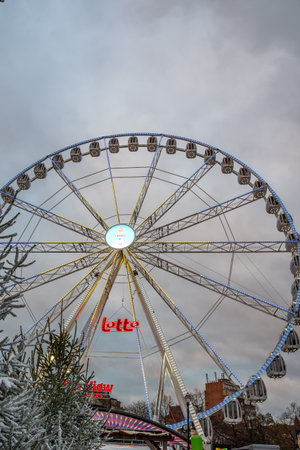 Brussels, Belgium - Nov 30, 2025: Illuminated Winter Wonders ferris wheel towering above snowy trees, with the Lotto sign visible at the base.のeditorial素材