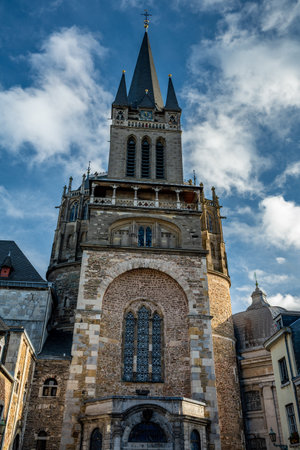 Medieval stone tower and westwork of Aachen Cathedral rising into dramatic winter clouds, a striking European architecture and heritage travel concept.の写真素材