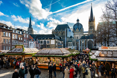Aachen, Germany - Dec 04, 2025: Crowds fill the Christmas market stalls with Aachen Cathedral skyline in the background under a bright winter sky.のeditorial素材