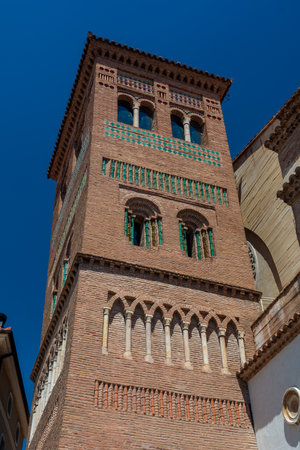Mudejar-style bell tower of the Church of San Pedro with intricate brickwork and glazed tile decorations under blue sky.のeditorial素材