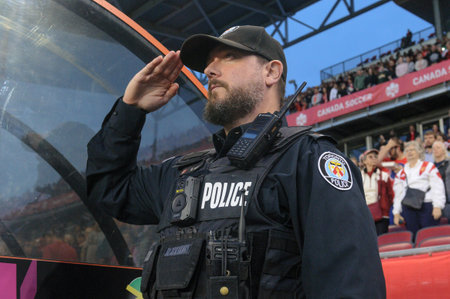 Toronto, ON, Canada - September 26, 2023: Police officer stands for the national anthem before the...