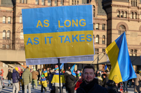 Toronto, Ontario, Canada â February 24, 2024:  Protestors with banners and Ukrainian flags in Downtown Nathan Phillips Square during the demonstration against the Russian invasion of Ukraineのeditorial素材