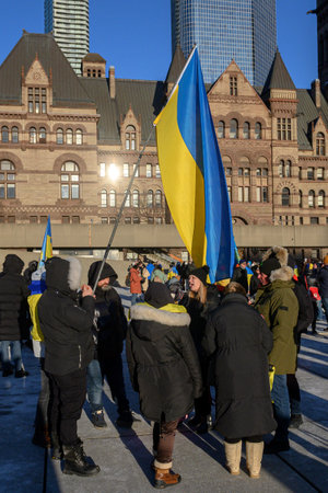 Toronto, Ontario, Canada â€“ February 24, 2024:  Protestors with banners and Ukrainian flags in...