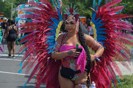 Toronto, ON, Canada - August 5, 2023: parade participant dressed in glittering feathered parade...