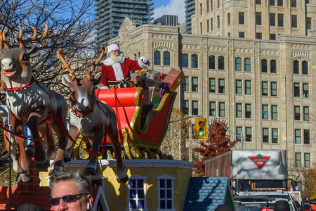 TORONTO, ONTARIO, CANADA - NOVEMBER 23, 2025: Santa Claus waves to the crowd while riding in his...