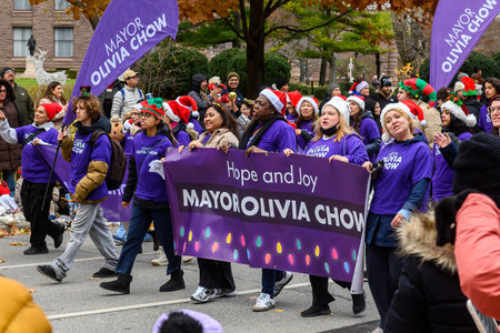 Toronto, ON, Canada - November 23, 2025: People wearing Santa hats and purple shirts carry a Hope...