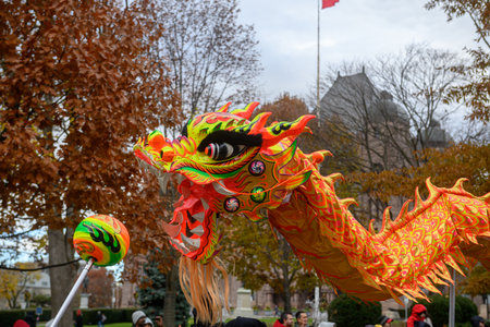 TORONTO, ONTARIO, CANADA - NOVEMBER 23, 2025: A colourful traditional Chinese Dragon Dance performance proceeds along the route of The Original Santa Claus Parade in Downtown Toronto.のeditorial素材