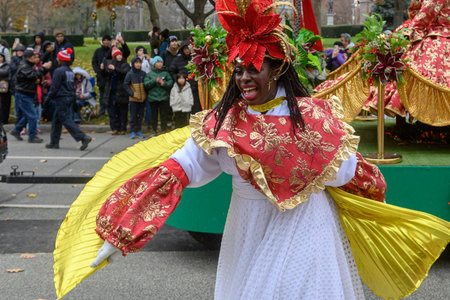 TORONTO, ONTARIO, CANADA - NOVEMBER 23, 2025: Participants in colourful, Caribbean-themed costumes stand on a decorated float adorned with palm trees and festive ribbons during The Original Santa Claus Parade in Downtown Toronto.のeditorial素材
