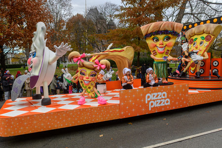 TORONTO, ONTARIO, CANADA - NOVEMBER 23, 2025: A brightly decorated float sponsored by Pizza Pizza, featuring giant pizza character props and children in chef costumes, proceeds through The Original Santa Claus Parade in Downtown Toronto.のeditorial素材
