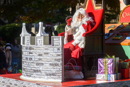 TORONTO, ONTARIO, CANADA - NOVEMBER 23, 2025: Mrs. Claus in a white wig and red velvet dress waves to the crowd from a richly decorated float, possibly sponsored by Casa Loma, during The Original Santa Claus Parade in Downtown Toronto.のeditorial素材