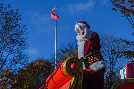 TORONTO, ONTARIO, CANADA - NOVEMBER 23, 2025: Santa Claus waves to the crowd while riding in his iconic red and gold sleigh, piled high with wrapped gifts, during the finale of The Original Santa Claus Parade in Downtown Toronto.のeditorial素材