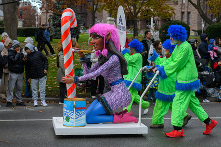 TORONTO, ONTARIO, CANADA - NOVEMBER 23, 2025: A festive float featuring a large, brightly coloured elf character and a giant candy cane prop proceeds along the route of The Original Santa Claus Parade in Downtown Toronto.のeditorial素材