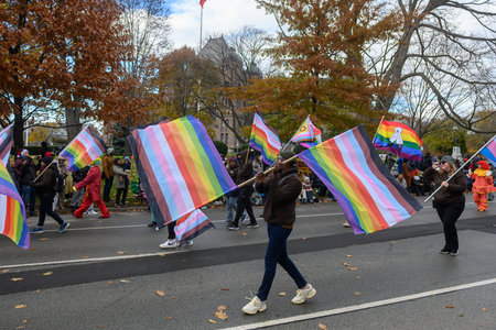 TORONTO, ONTARIO, CANADA - NOVEMBER 23, 2025: Participants carrying numerous Progress Pride Flags march along the route of The Original Santa Claus Parade in Downtown Toronto, integrating LGBTQ+ representation into the festive event.のeditorial素材