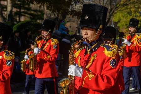 TORONTO, ONTARIO, CANADA - NOVEMBER 23, 2025: The full contingent of a marching band in spectacular scarlet (red) uniforms and tall black hats proceeds down the route of The Original Santa Claus Parade in Downtown Toronto.のeditorial素材