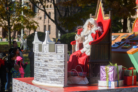 TORONTO, ONTARIO, CANADA - NOVEMBER 23, 2025: Mrs. Claus in a white wig and red velvet dress waves to the crowd from a richly decorated float, possibly sponsored by Casa Loma, during The Original Santa Claus Parade in Downtown Toronto.のeditorial素材