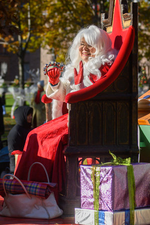 TORONTO, ONTARIO, CANADA - NOVEMBER 23, 2025: Mrs. Claus in a white wig and red velvet dress waves to the crowd from a richly decorated float, possibly sponsored by Casa Loma, during The Original Santa Claus Parade in Downtown Toronto.のeditorial素材