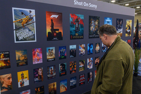 Toronto, ON, Canada - November 6, 2025: Man in a green jacket looking at a wall display of movie and...