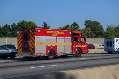Toronto, ON, Canada - June 3, 2025: Toronto Fire Services Squad 143 fire truck and ambulance racing down highway with lights and sirens responding to emergency incidentのeditorial素材