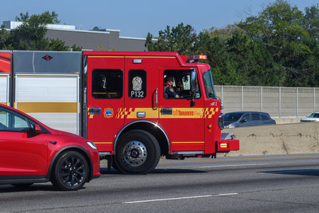 Toronto, ON, Canada - June 3, 2025: Red Toronto Fire P132 truck driving in traffic, responding to an...