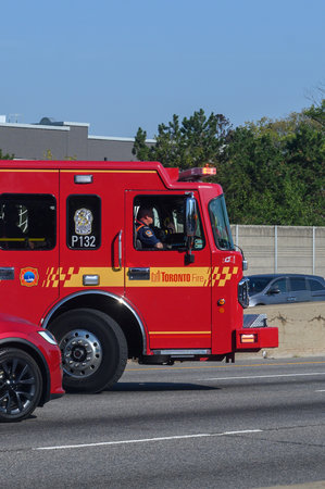 Toronto, ON, Canada - June 3, 2025: Red Toronto Fire truck driving on a multi-lane highway with a...