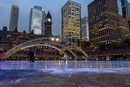 Toronto, ON, Canada - December 3, 2025: People enjoying ice skating on a winter evening at Nathan...