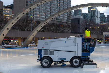 Toronto, ON, Canada - December 3, 2025: Worker operating an ice resurfacing machine, meticulously...