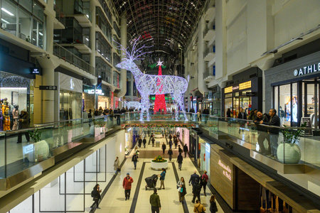 Toronto, ON, Canada - December 24, 2025: People shopping inside the multi-level CF Eaton Centre mall, featuring large illuminated reindeer and Christmas tree decorations, creating a festive holiday atmosphereのeditorial素材