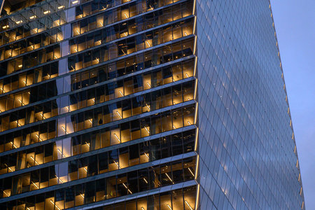 Toronto, ON, Canada - November 11, 2025: A modern office building's glass facade reflects twilight,...