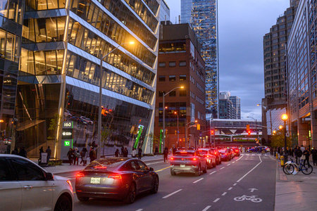 Toronto, ON, Canada - November 11, 2025: Evening street scene shows cars and people in the city...