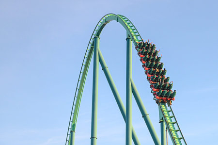 Toronto, ON, Canada - September 30, 2025: A green roller coaster ascends a peak, promising...