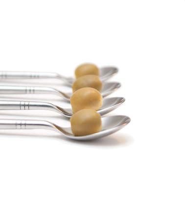 Green olives aligned on teaspoonsの写真素材
