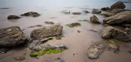Long exposure of rocks on wet sand