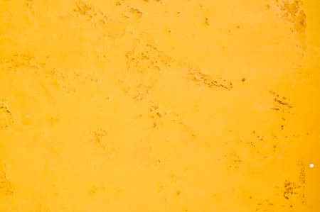 Yellow painted wall with spots of rust