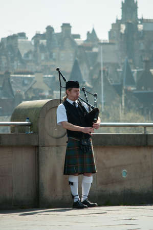 Edinburgh May 2012: Scottish Piper playing with Edinburgh city backgroundのeditorial素材