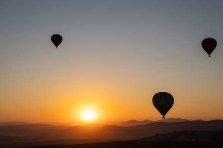 Beautiful nature landscape of countryside mountains with colorful high hot air balloons in summer sky. Vacation travel panorama background.の写真素材