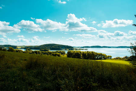 Landscape photo of amazing and beautiful nature with green grass, blue sky and river.の写真素材