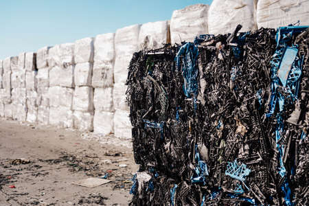 Photo of a large amount of waste paper, carton, car and plastic.