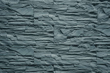 Photo of a wall in gray stone brick.