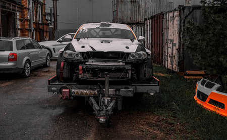 Photo of a white wrecked sport car on a trailer on the street.の写真素材