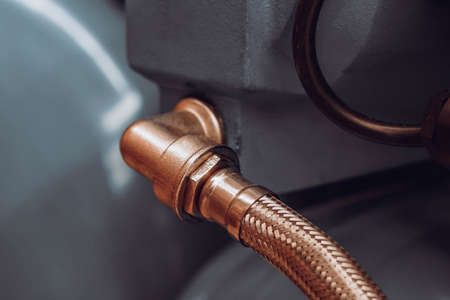 Photo of a gold metal pipe at the junction with a detail.