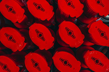 Photo of bottles with construction fluids and materials with red lids in a hardware store.の写真素材