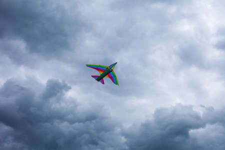 Photo of an airplane that flies in the blue sky with white clouds and gray clouds.