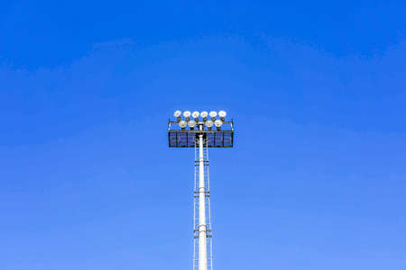 Photo of a sports lantern on a sports field against a blue clear sky.