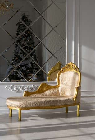 Beautiful decorative semi-antique sofa in an expensive studio with mirrored walls.の写真素材