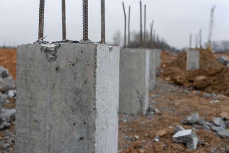 Photo of construction metal rods in concrete pillars against the background of a construction site...